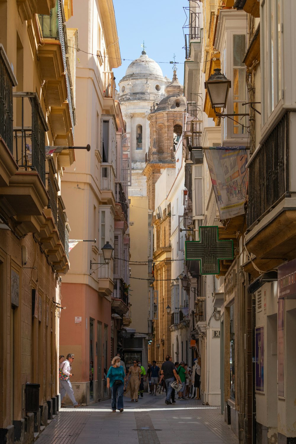 a group of people walking down a street next to tall buildings