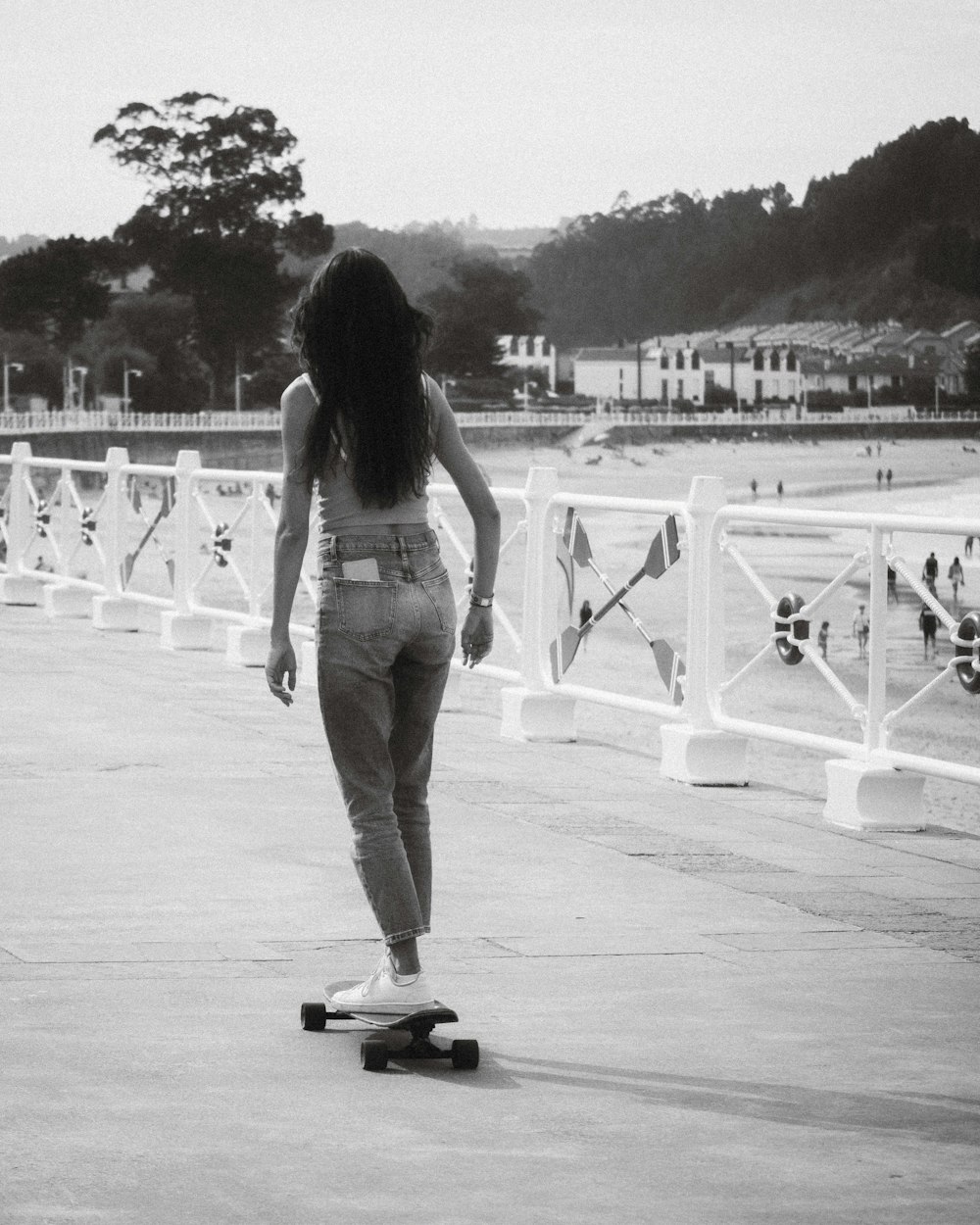 a woman riding a skateboard down a sidewalk