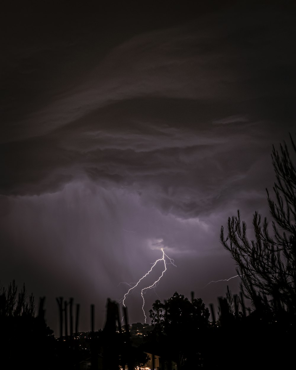 a lightning storm is seen over a city at night