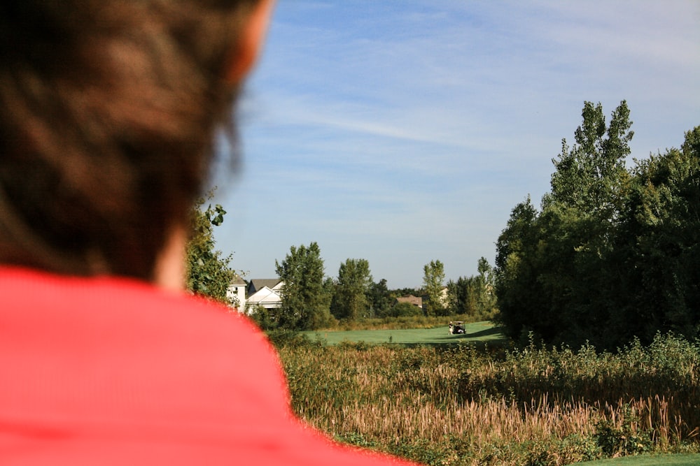 a woman in a red shirt is flying a kite