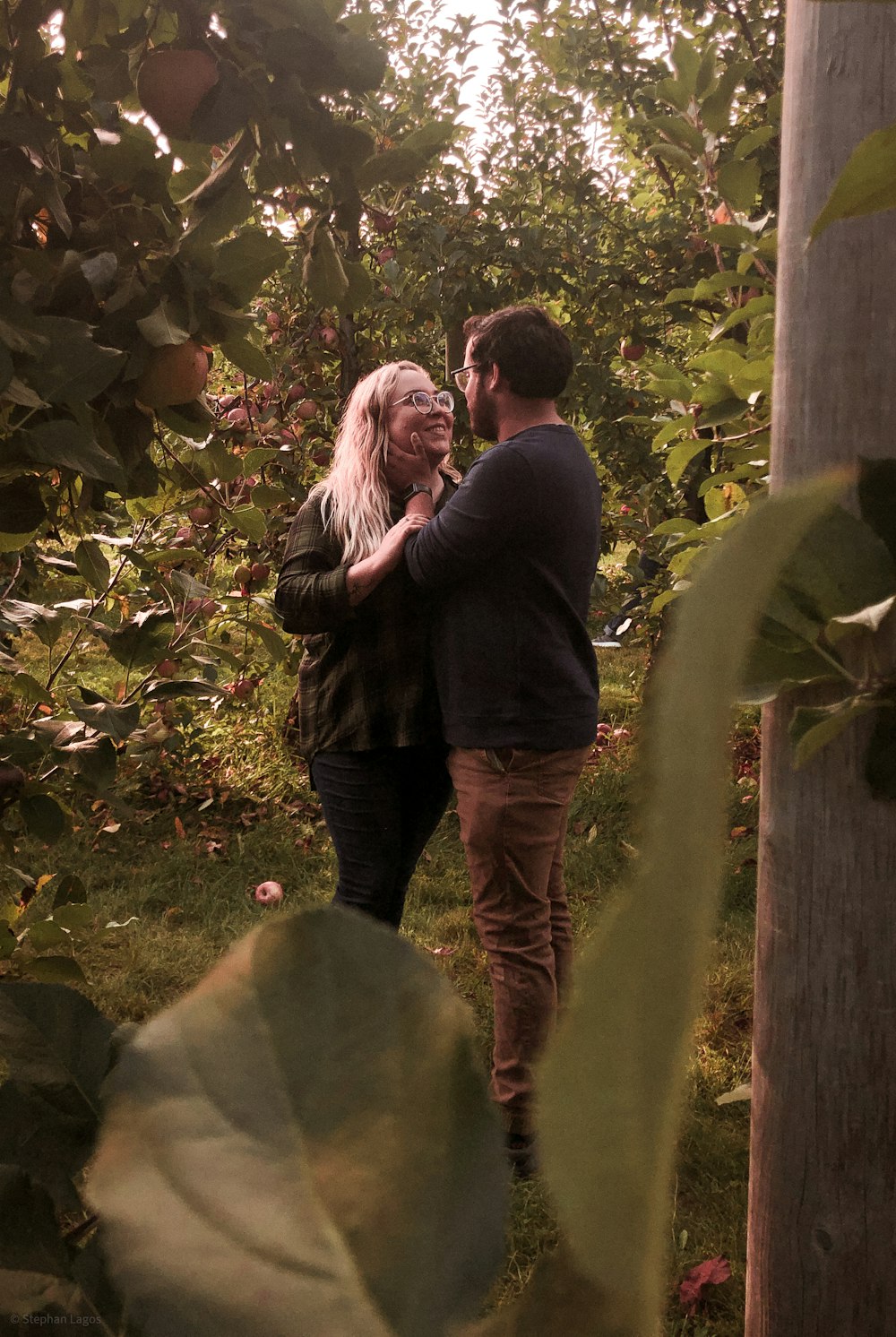 a man standing next to a woman in a forest