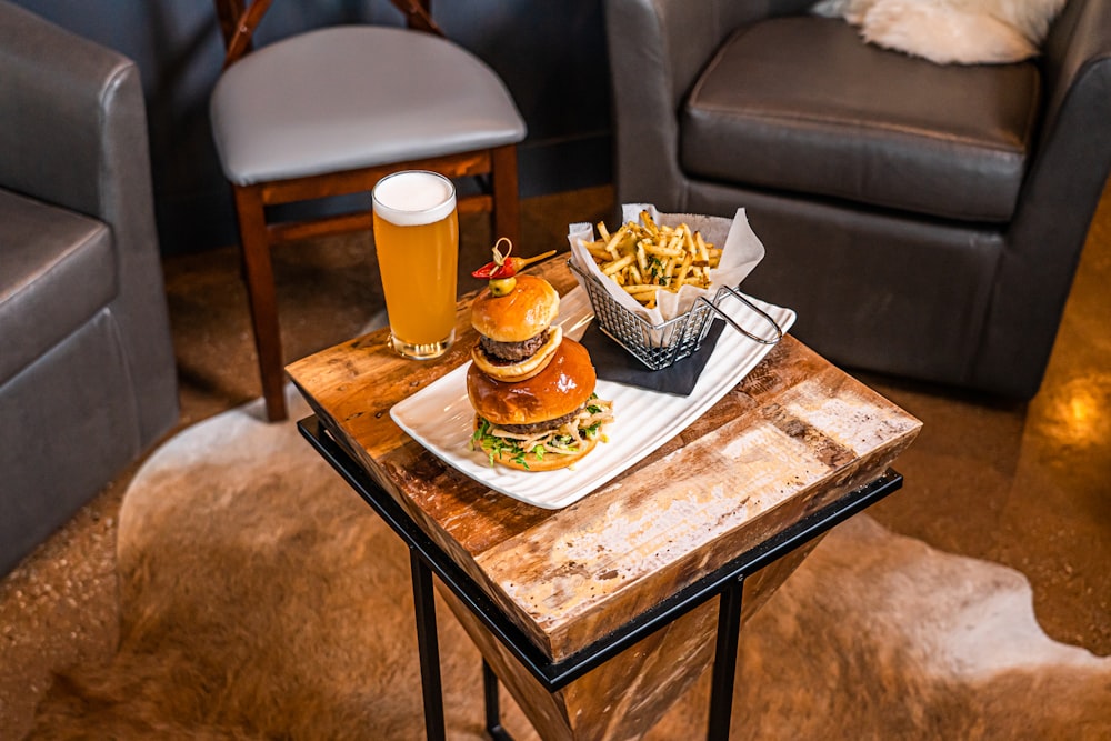 a wooden table topped with a burger and fries