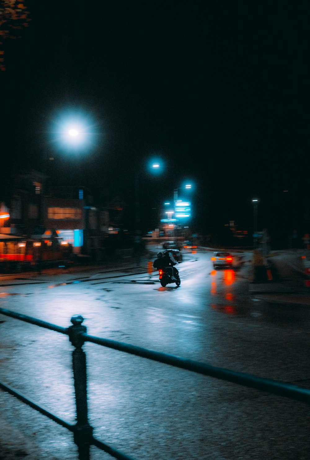 a person riding a motorcycle down a street at night