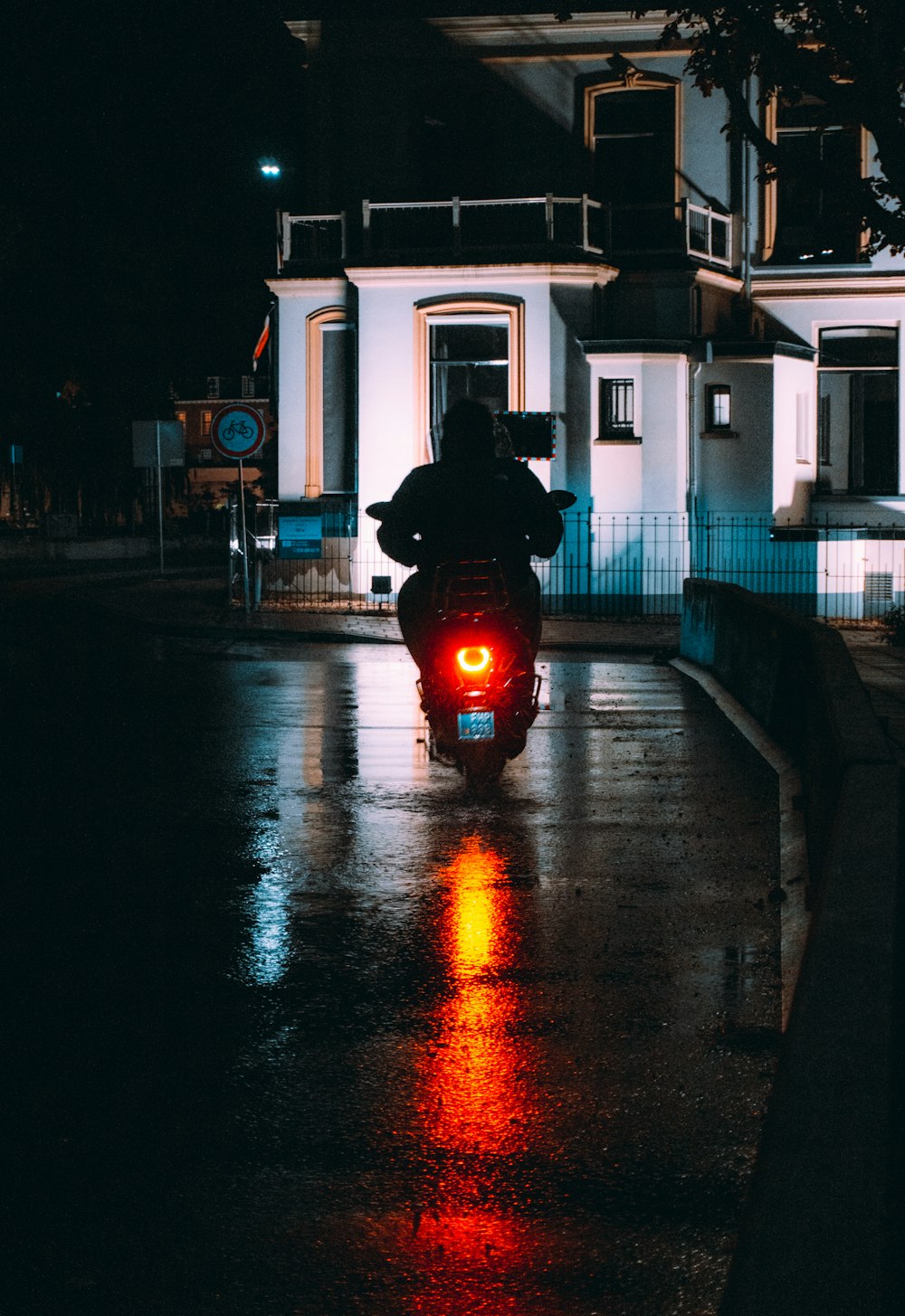 a person riding a motorcycle down a street at night
