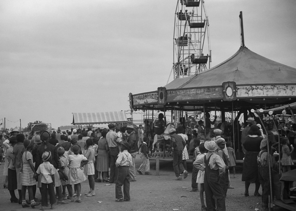 a crowd of people standing around a carnival ride