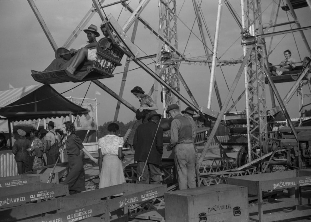 a group of people standing around a carnival ride