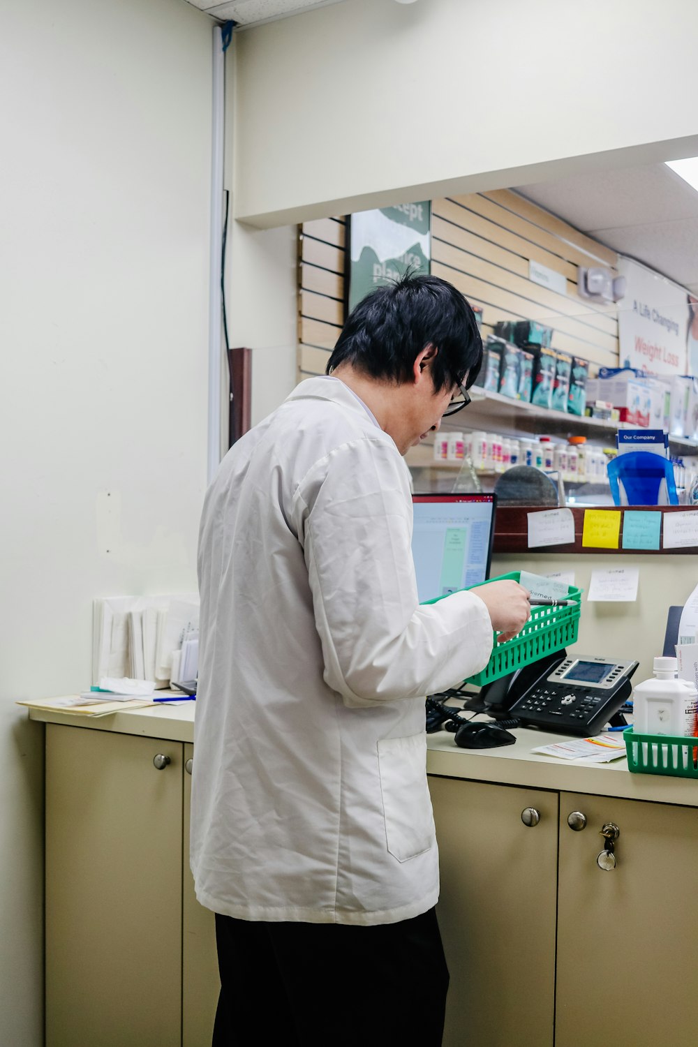 a man standing at a cash register in a pharmacy