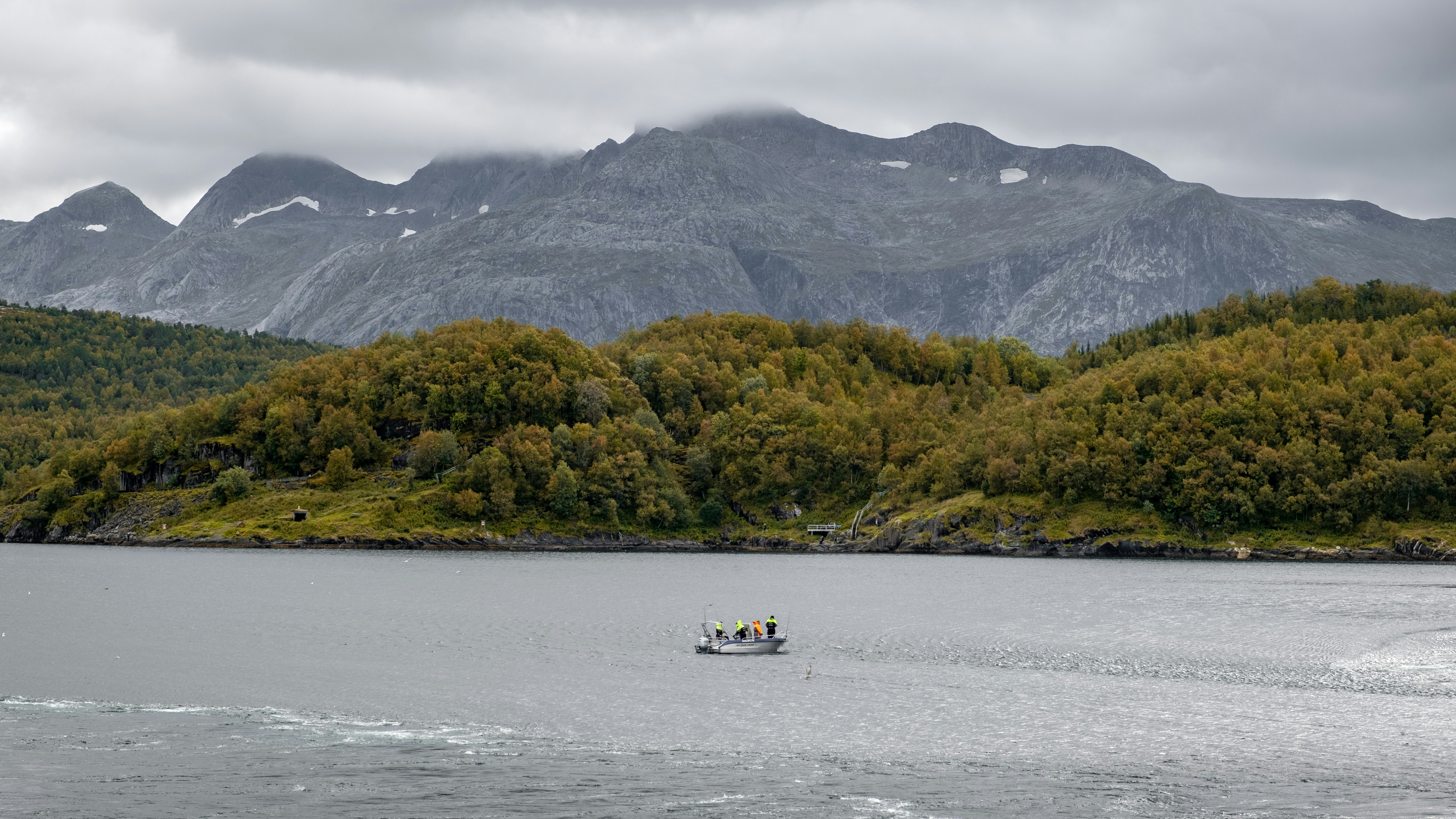 Un bateau dans un plan d’eau avec des montagnes en arrière-plan photo ...