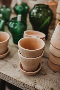A collection of colorful terracotta pots arranged on a wooden table.