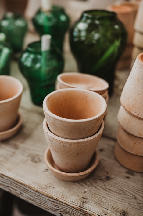 A collection of colorful terracotta pots arranged on a wooden table.