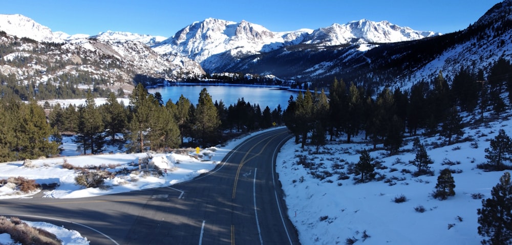 a road in the mountains with a lake in the distance