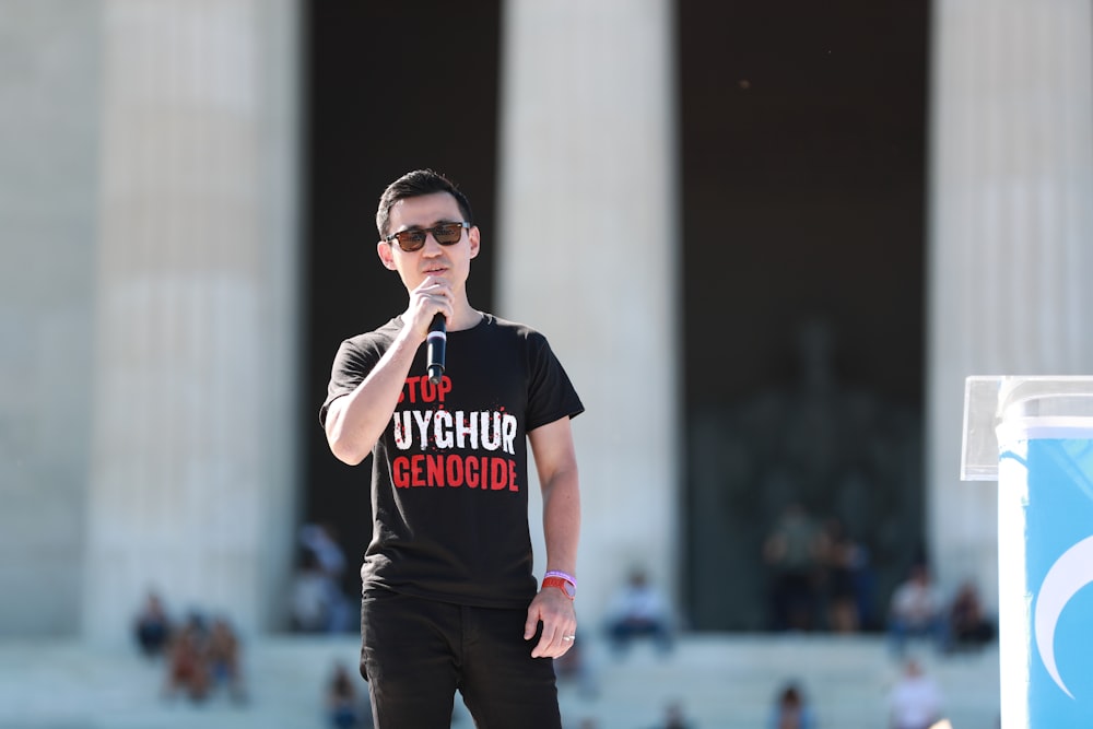 a man standing in front of a building holding a microphone