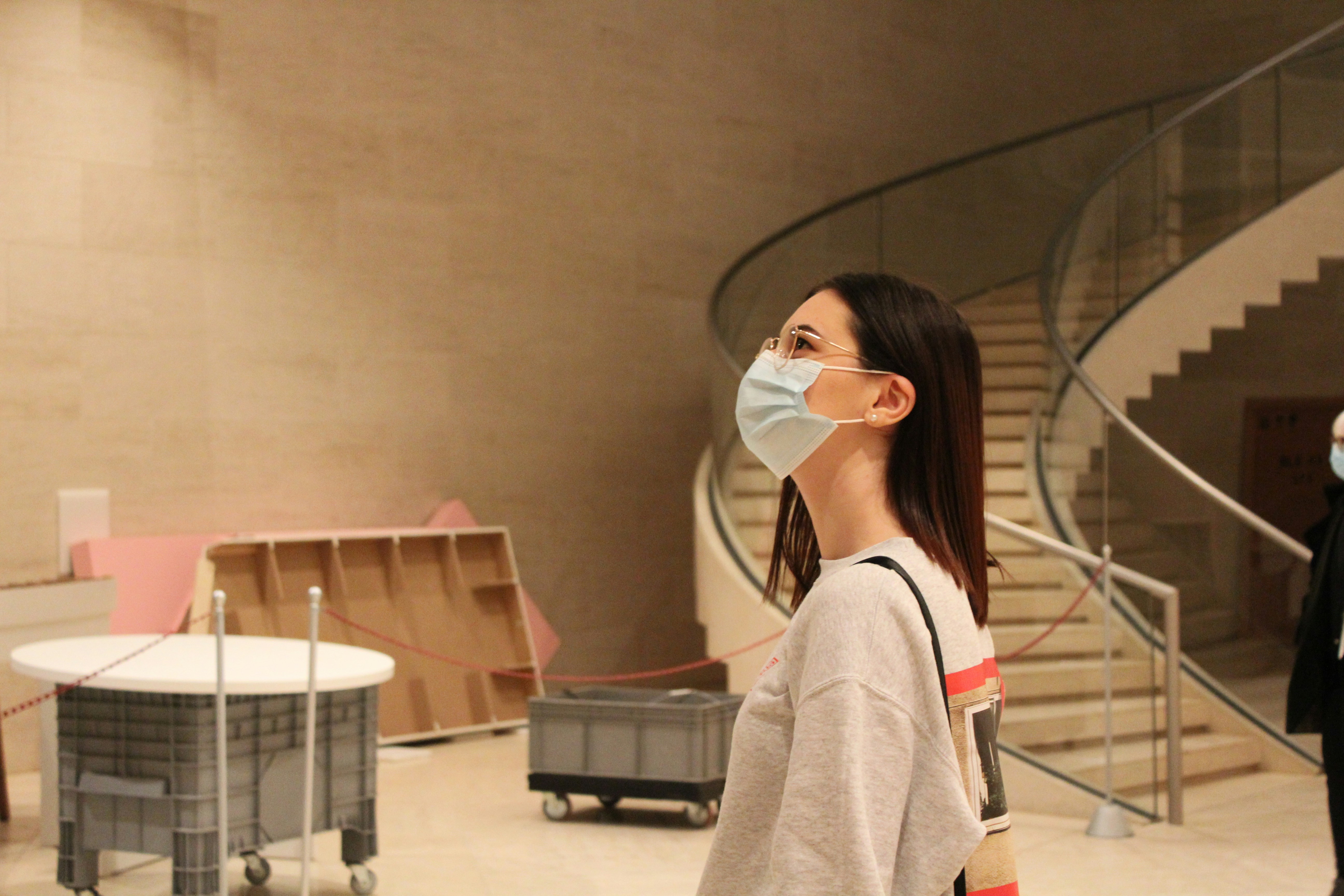 A woman wearing a face mask in a building photo – Free Human Image on ...