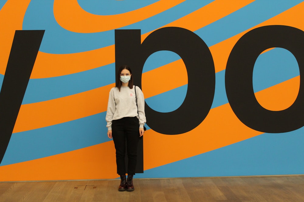 a woman standing in front of a colorful wall