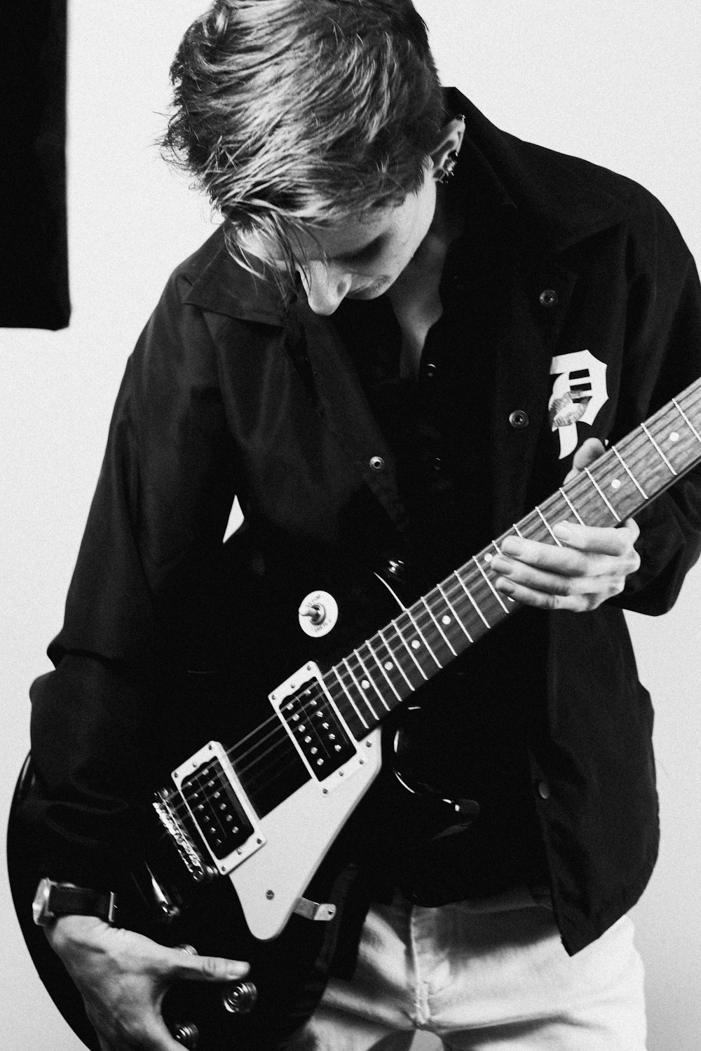 a black and white photo of a person playing a guitar