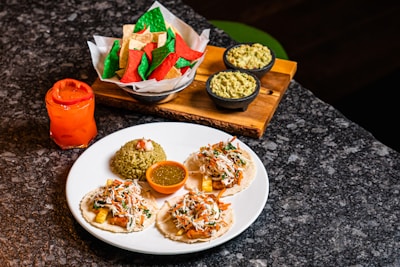 A vibrant spread of colorful Mexican dishes including tacos, salsas, and fresh guacamole.