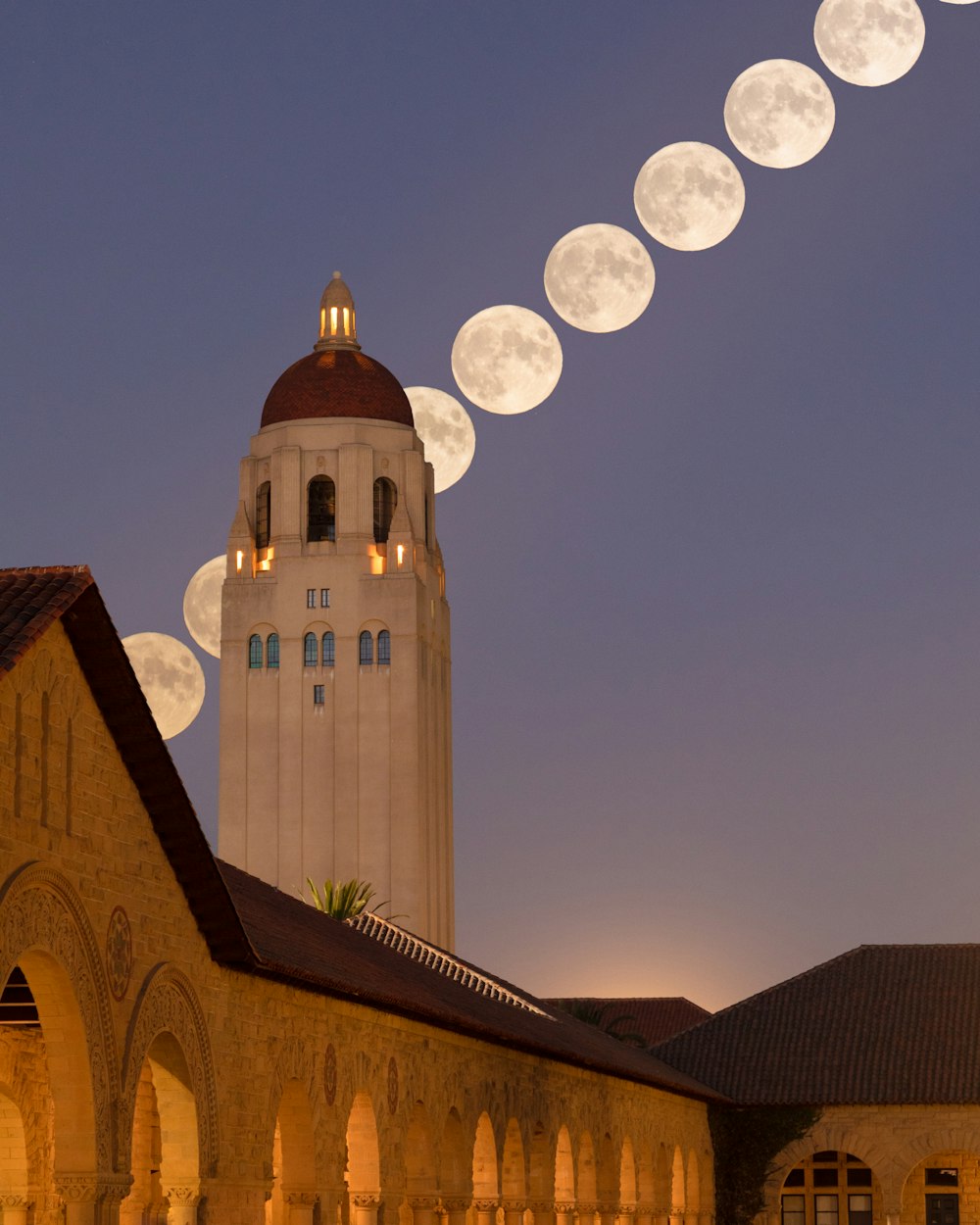 a building with a clock tower and a long line of lights