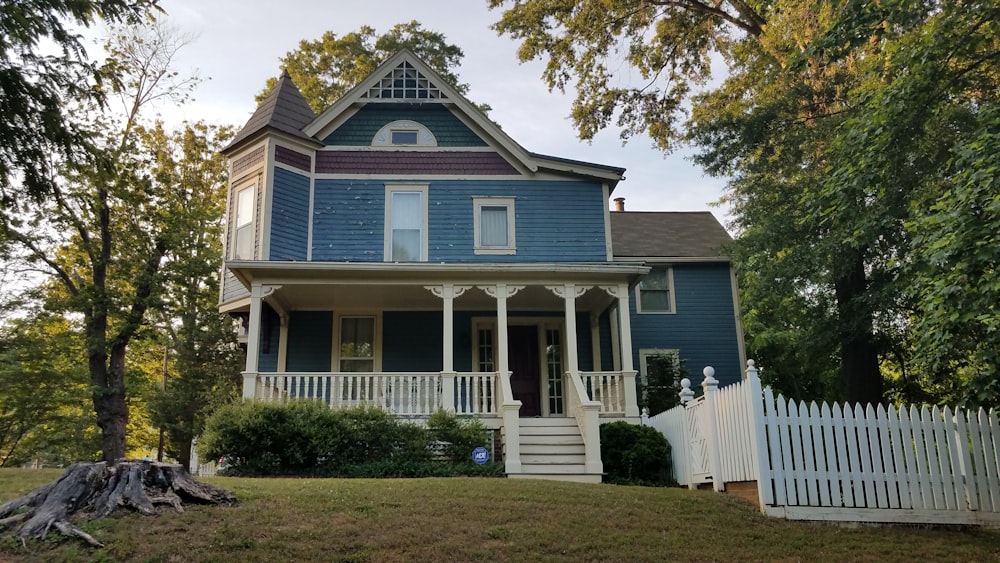 a blue house with a white picket fence