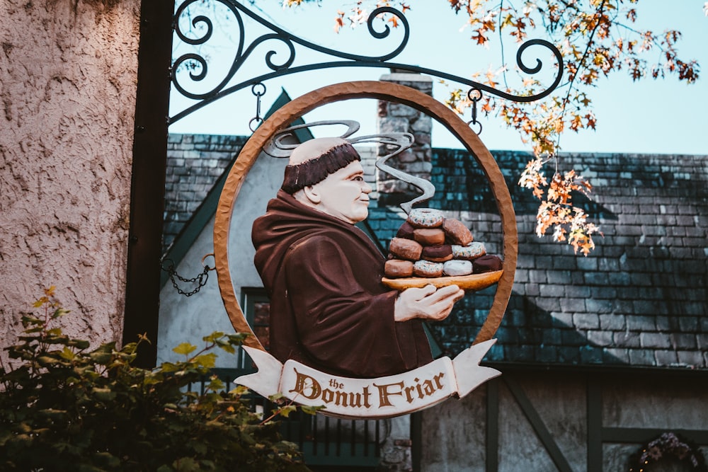 a statue of a monk holding a tray of donuts