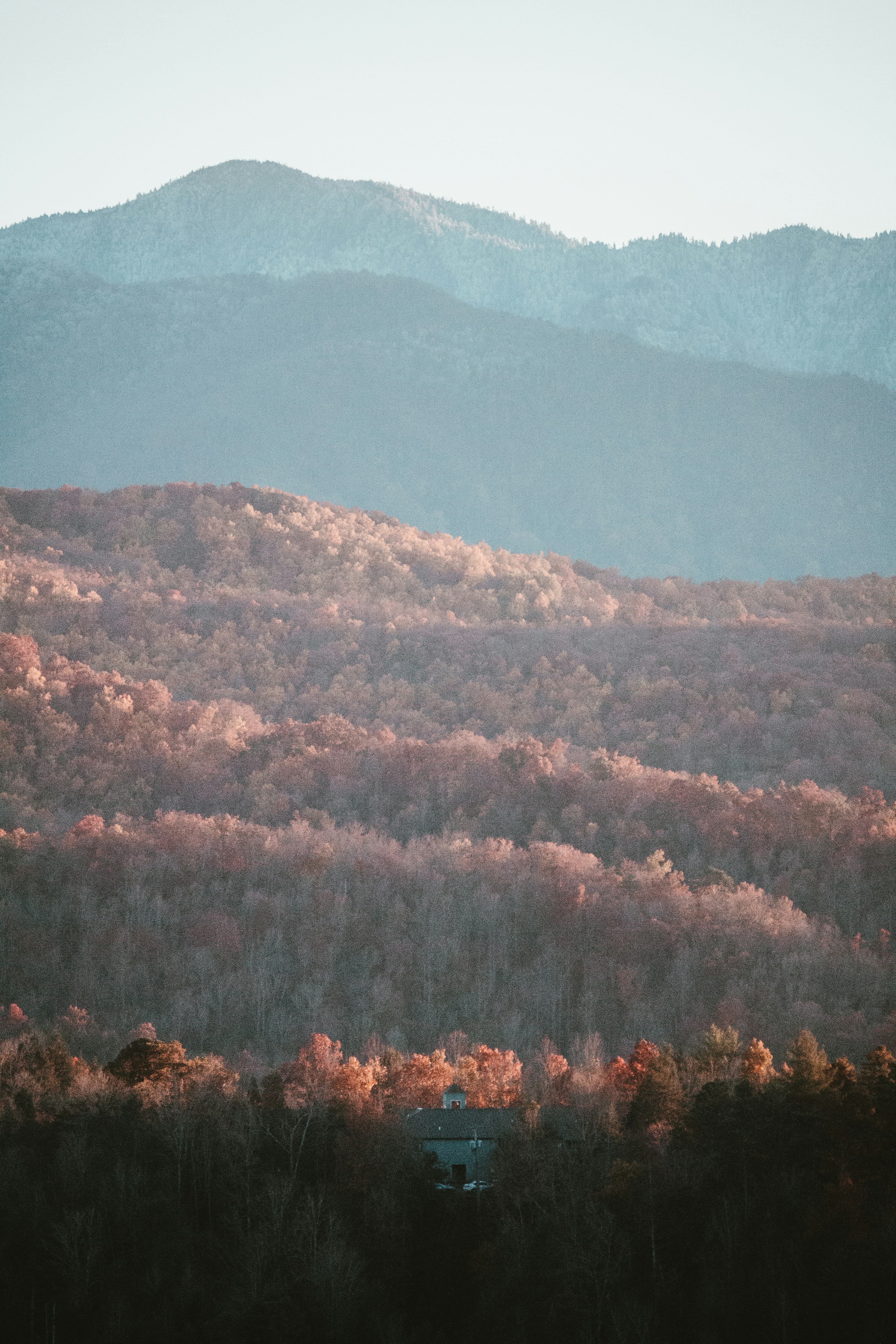 Una vista de una cadena montañosa con una casa en primer plano