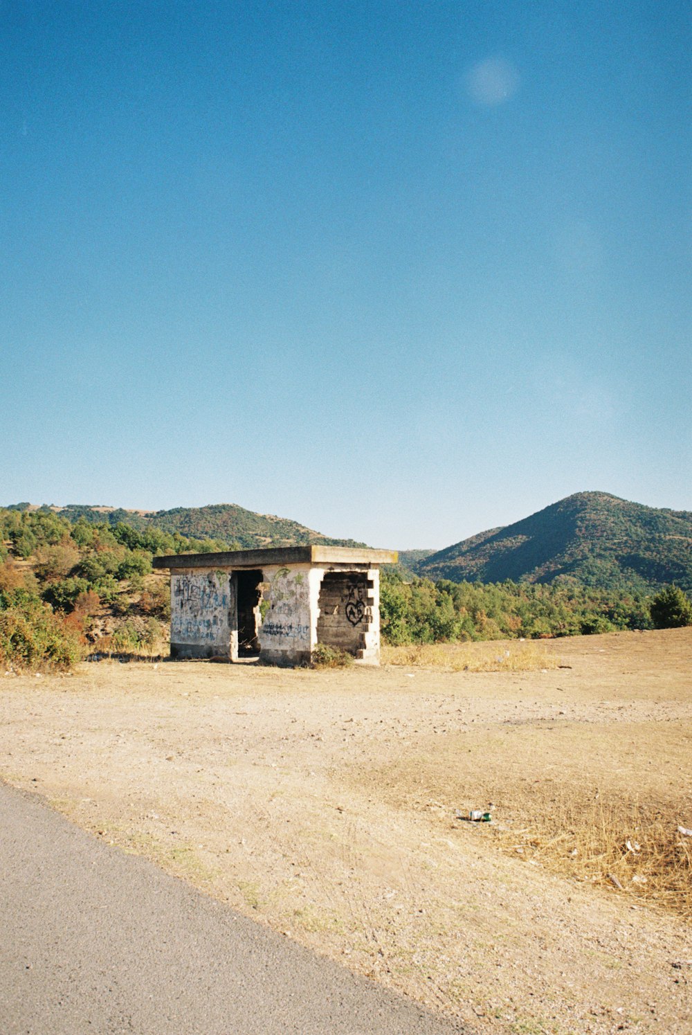 a small building sitting on the side of a road