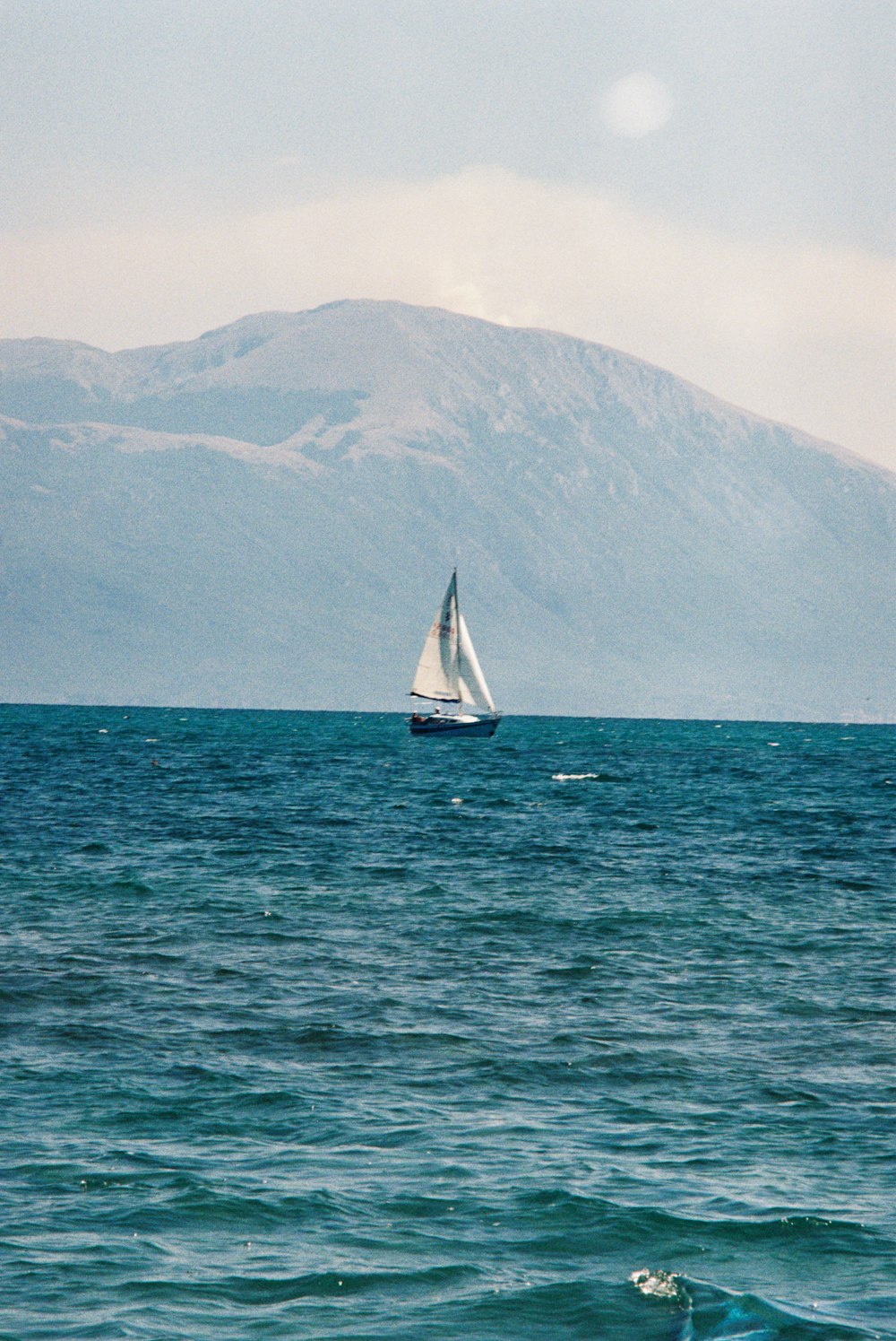 a large body of water with a mountain in the background