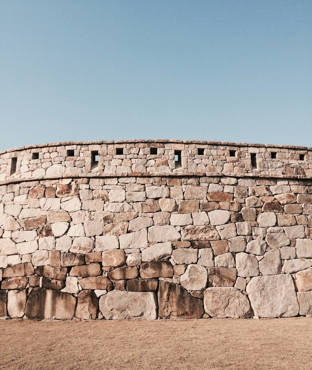 a stone wall with a clock on top of it