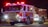 Close-up of a technician installing emergency vehicle lighting on a fire truck.