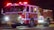 Close-up of a technician installing emergency vehicle lighting on a fire truck.