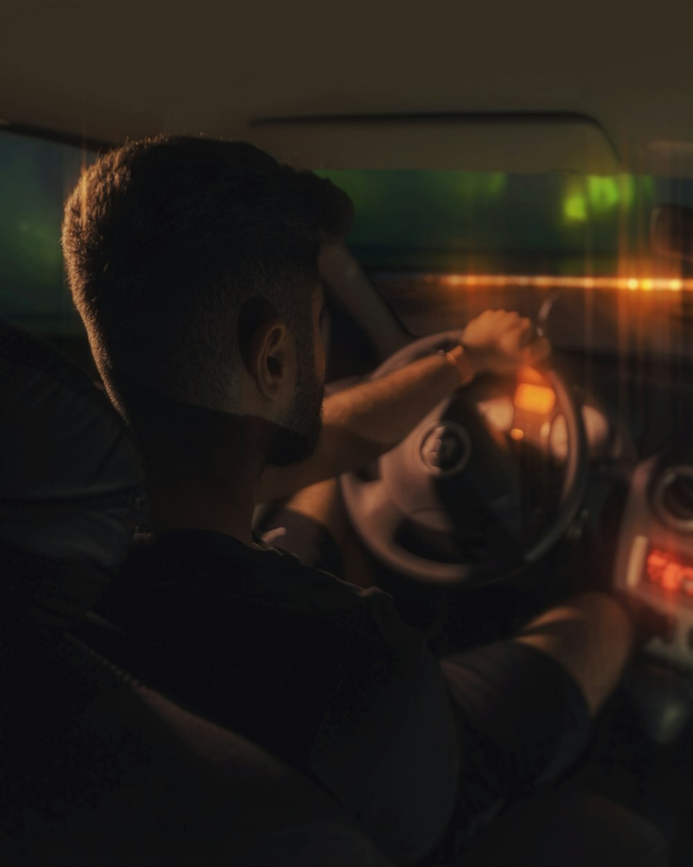 a man sitting in a car holding a steering wheel