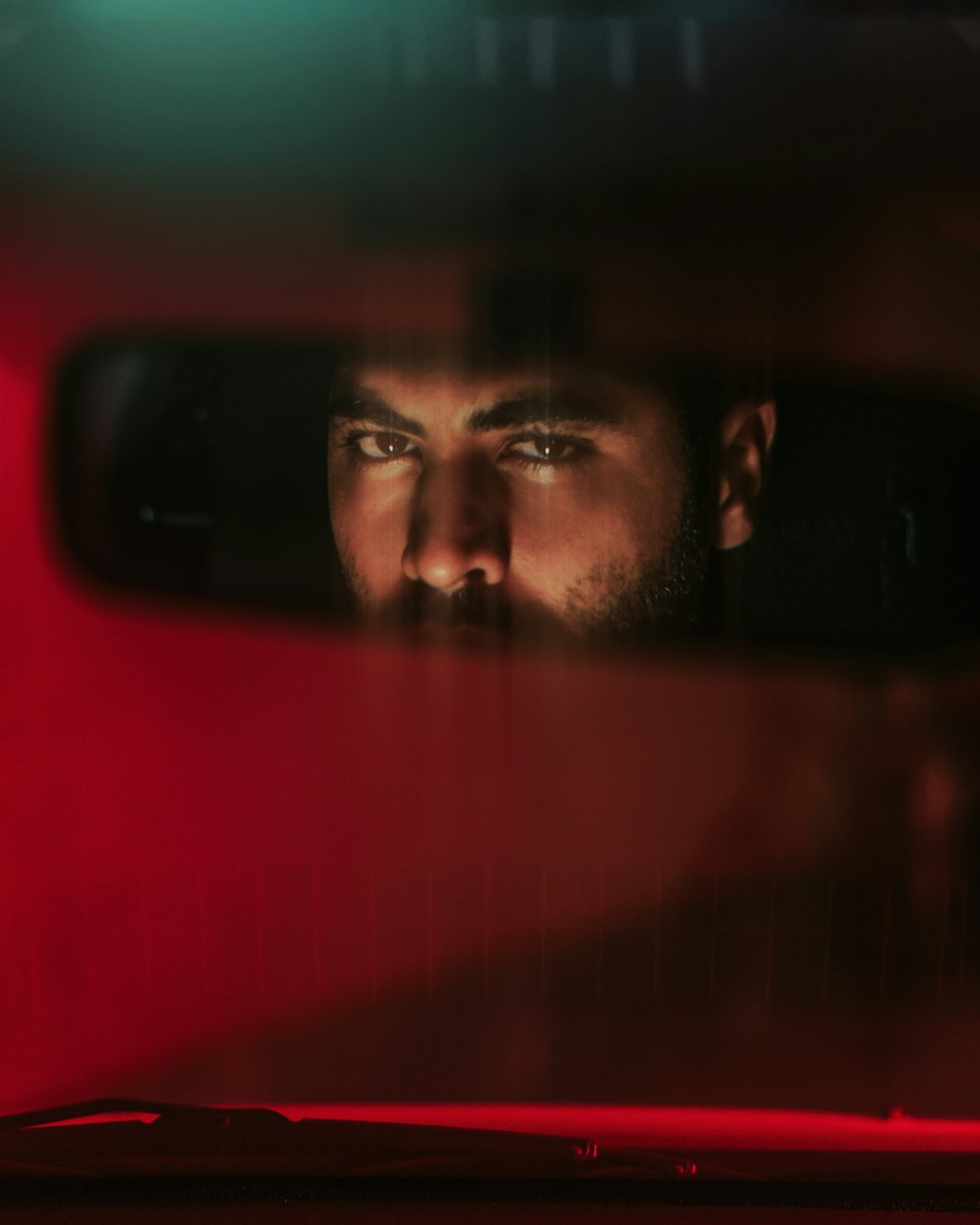 a man's reflection in a rear view mirror