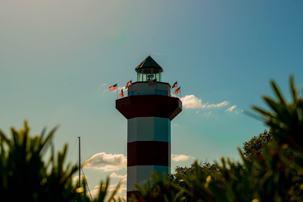 a red and white tower with a clock on top