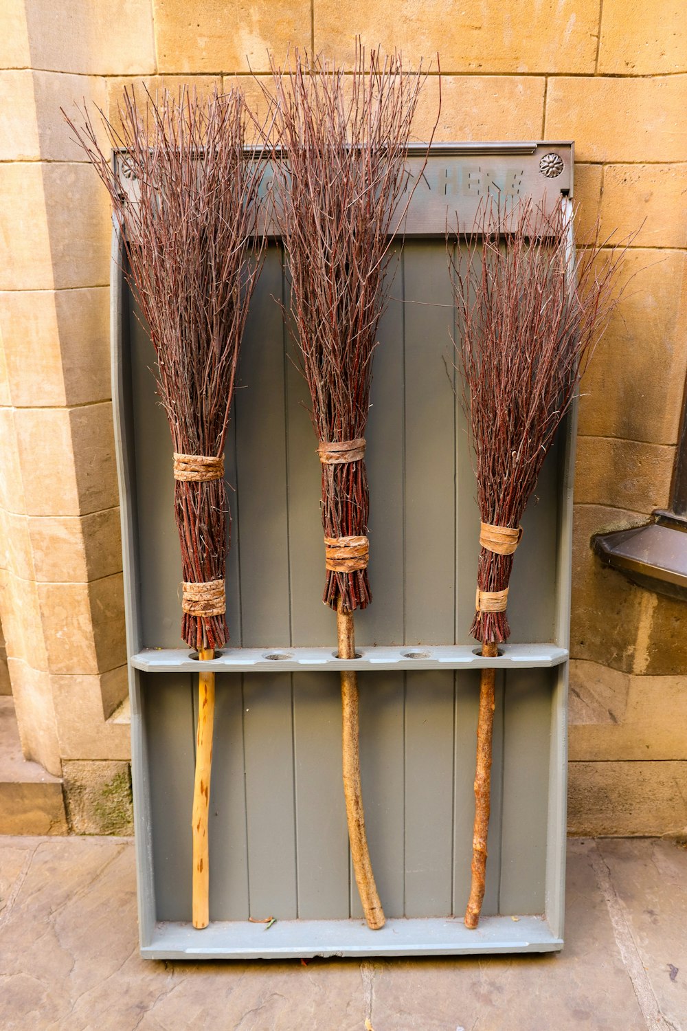 a couple of brooms sitting on top of a shelf