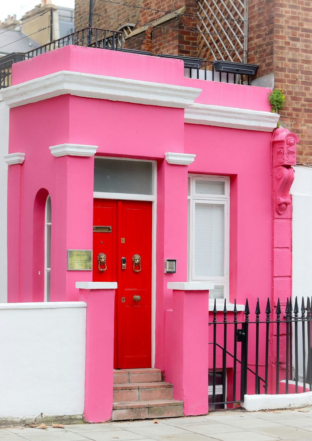 a bright pink house with a red door