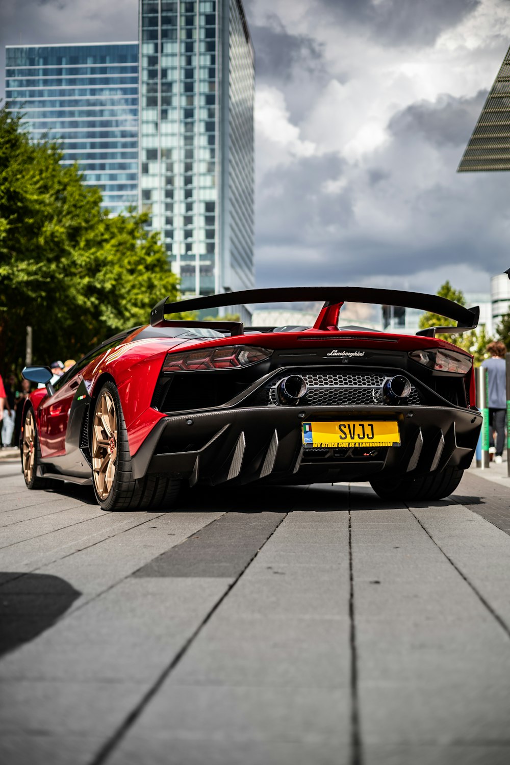 a red sports car parked in front of a tall building