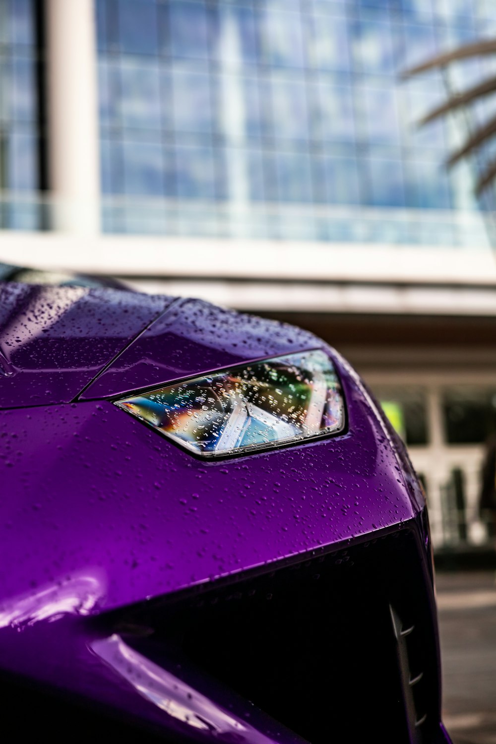 a close up of a purple car with a building in the background