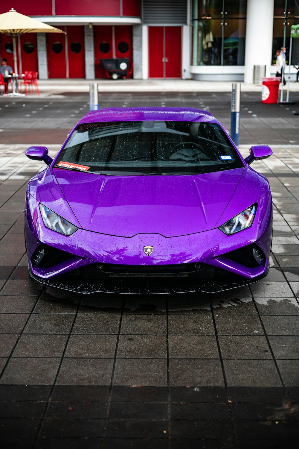 a purple sports car parked in front of a building