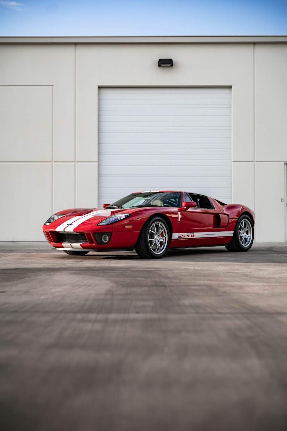 a red sports car parked in front of a garage