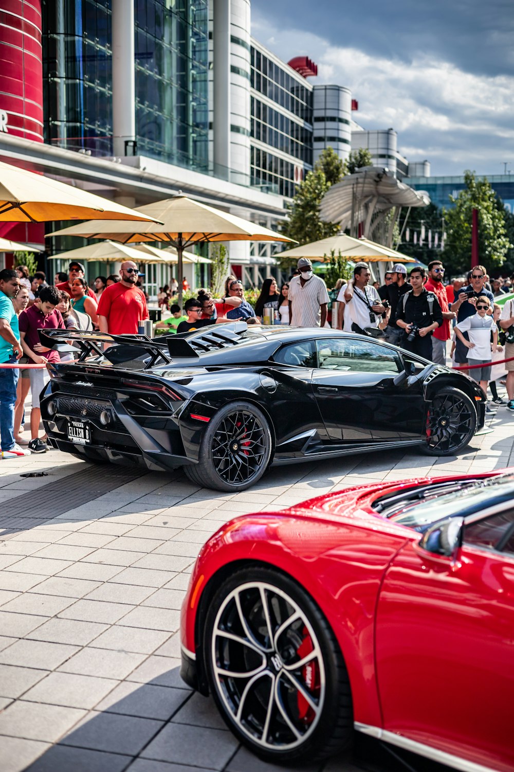 a group of people standing around a bunch of cars