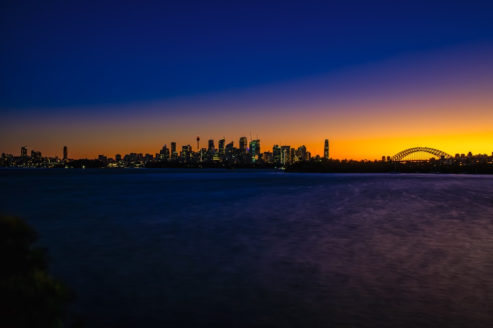 a view of a city at sunset with a bridge in the foreground