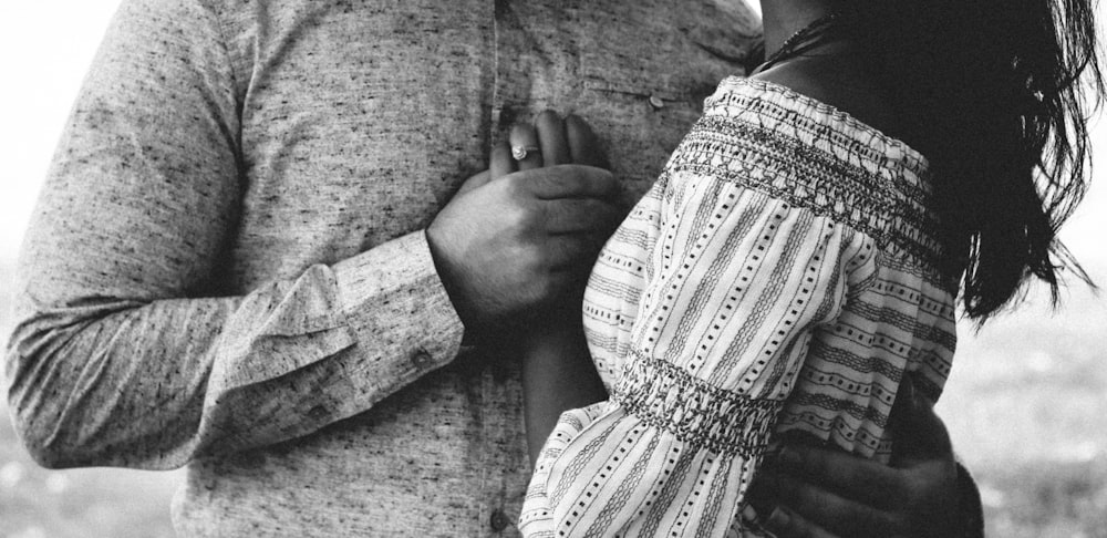 a black and white photo of a couple holding each other