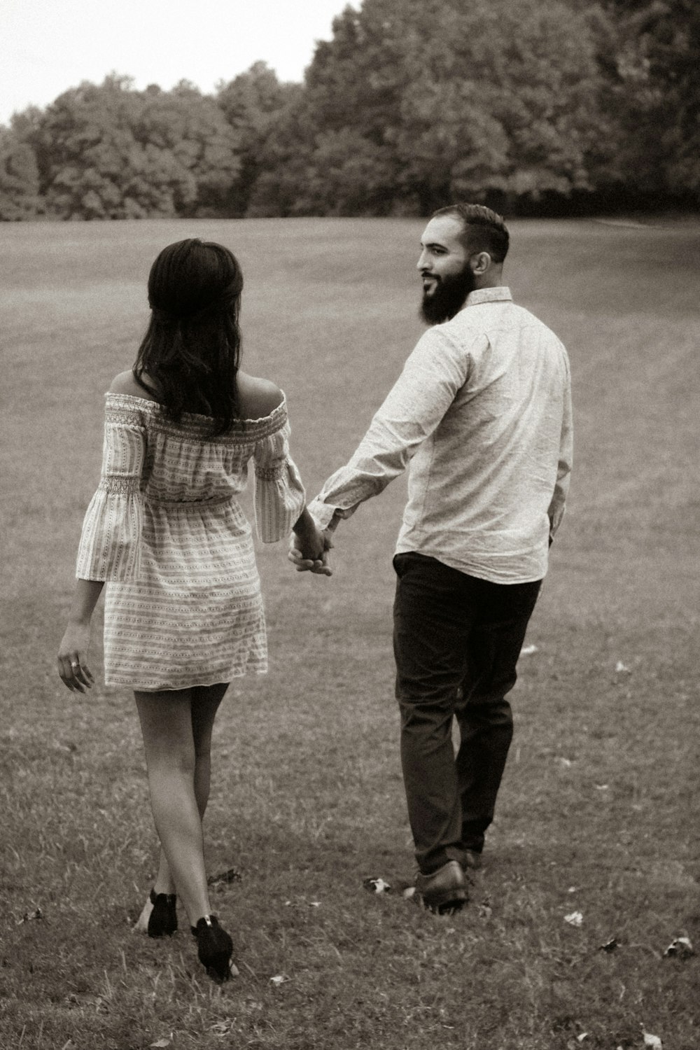 a man and a woman holding hands in a field