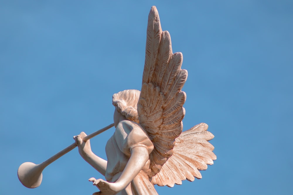 Una estatua de un ángel sosteniendo un bate de béisbol