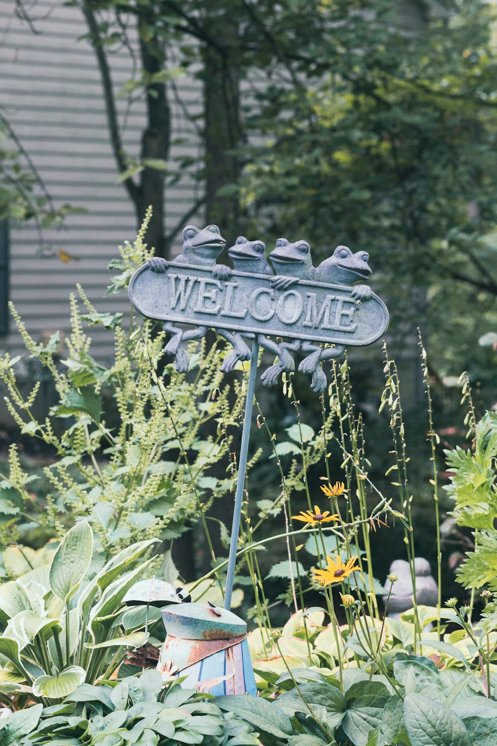 a welcome sign in the middle of a garden