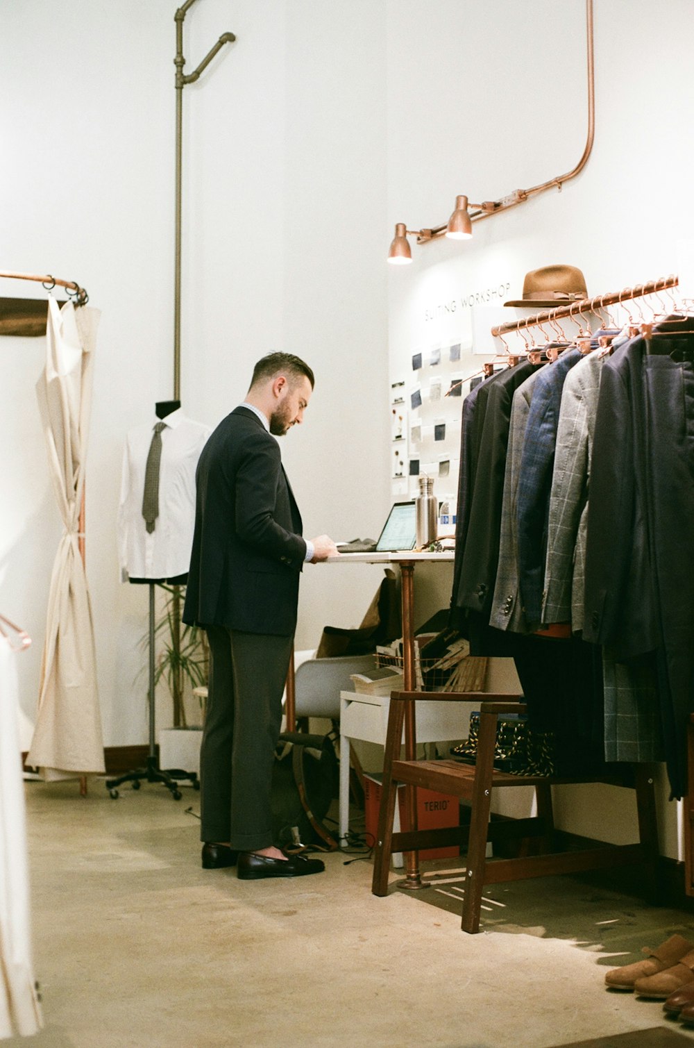 Un hombre parado frente a un estante de ropa
