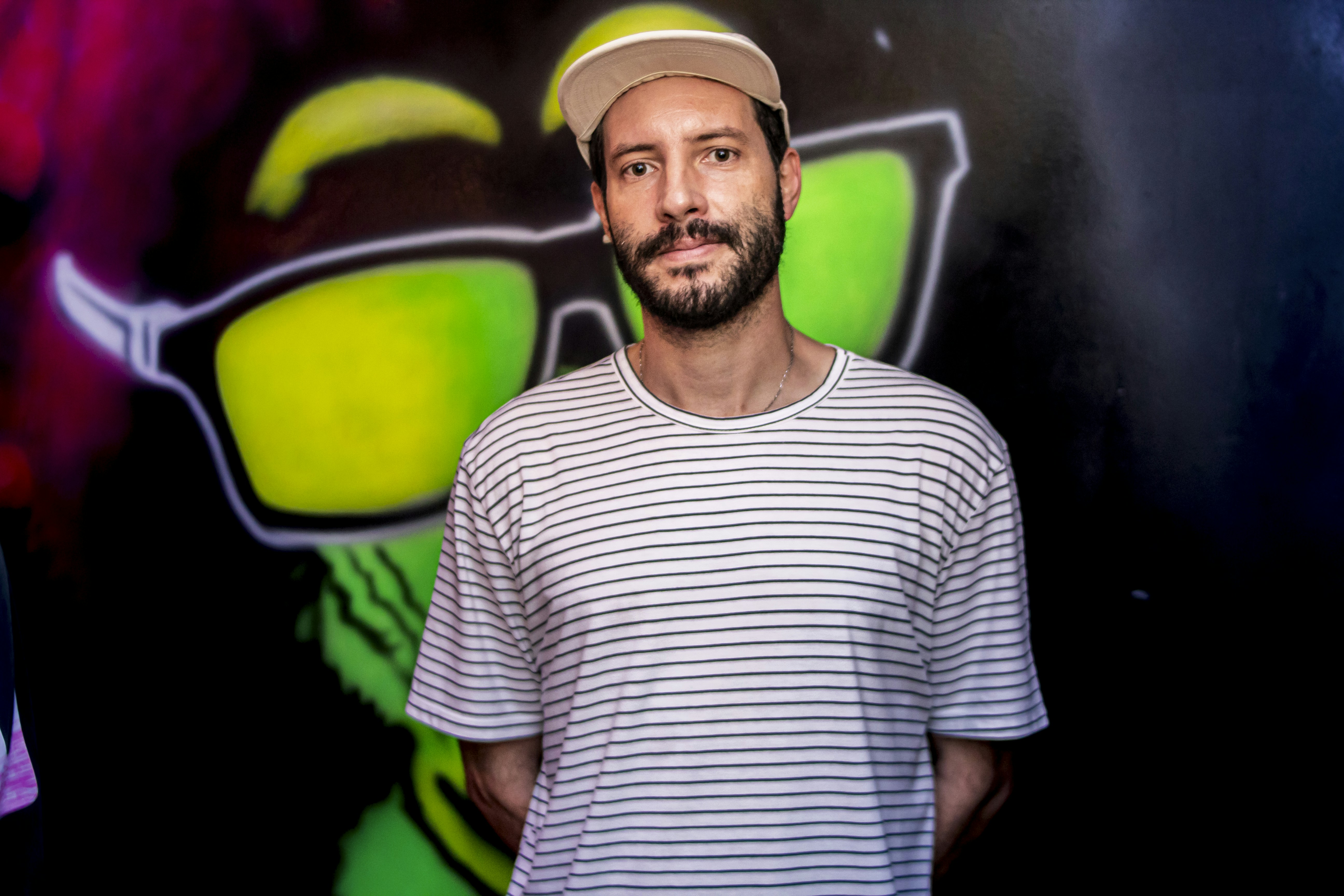 a man standing in front of a colorful wall