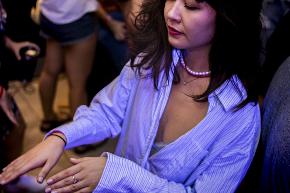 a woman sitting in a chair holding a cell phone