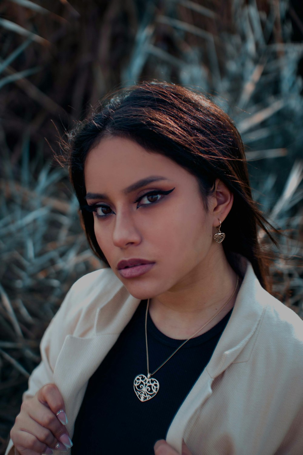 a woman wearing a jacket and a necklace