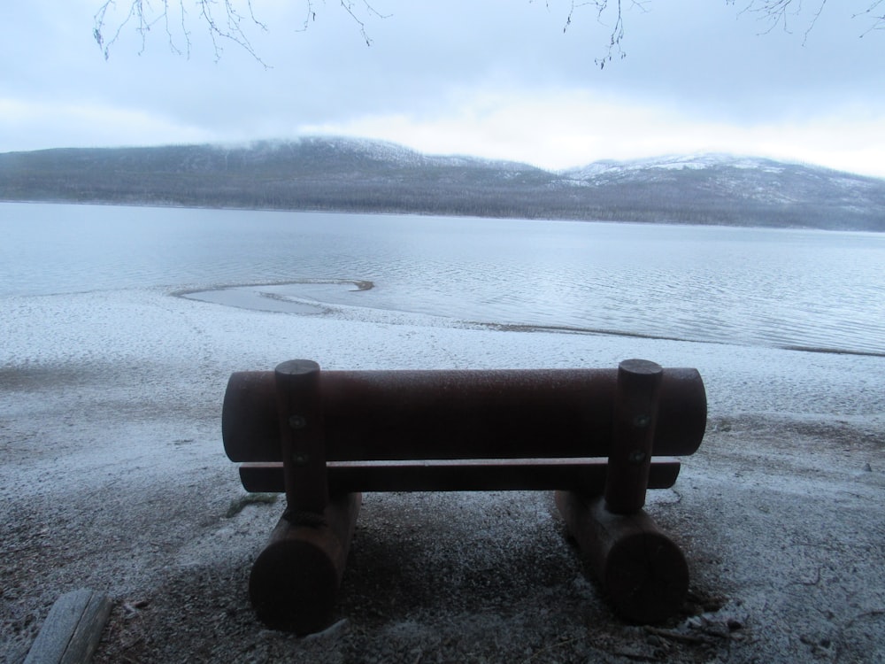 a bench sitting on top of a sandy beach