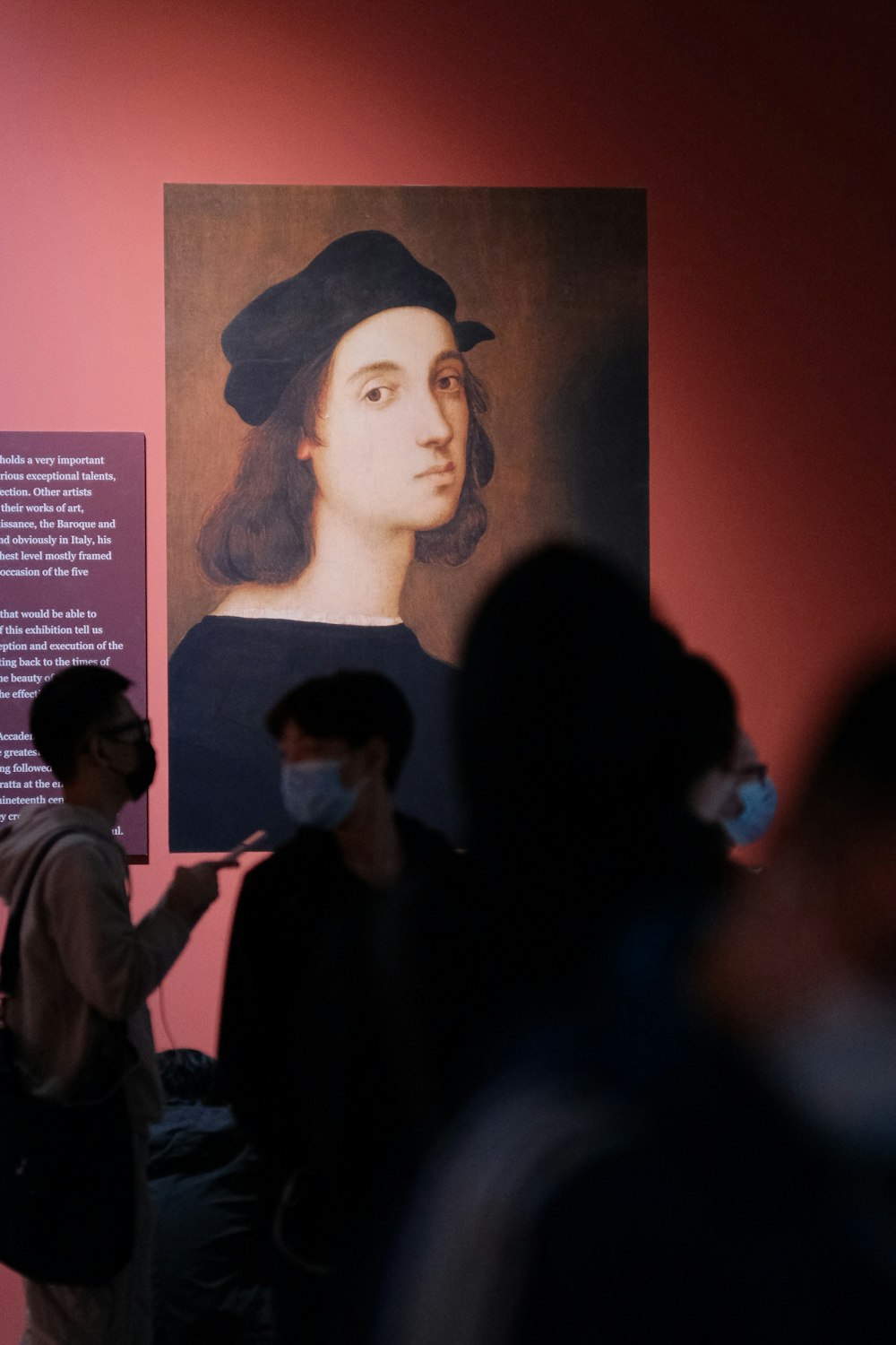 a group of people standing in front of a painting